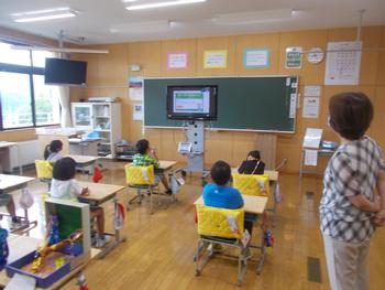 教室内でモニターをみている子供たちを右斜め後方から写した写真