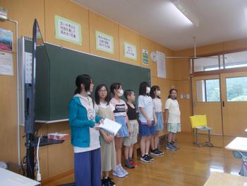 教室の黒板の前に7名の生徒が立ち横一列に並んでいる写真