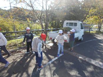 集めた落ち葉をトラックに運んでいる子供たちの写真