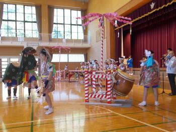 体育館の舞台の前で入谷打囃子を披露している子供たちを横から写した写真