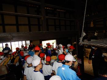 広い小屋のようなところで体操服姿の子供たちがみんなはいって説明を聞いているふるさと学習会の写真