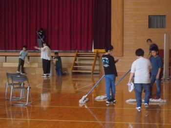 モップやぞうきんを使い体育館の床を掃除している子供たちの写真