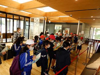 展示物にさわれないように仕切りがされている室内で見学をしている生徒たちの写真