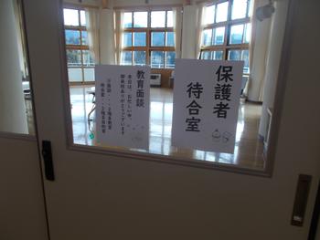 ガラス扉越しに「保護者待合室」と書かれた紙が貼られた室内が映っており、日差しの差し込む広々とした明るい部屋の様子が見える写真