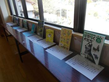 窓際に長机が設置されいろいろな本が紹介され展示されている様子を写した写真