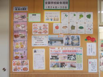 給食週間を知らせるポスターや給食の歴史、地元の食材、給食クイズなどの掲示物が壁いっぱいに貼られた写真