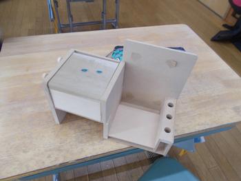 色付け途中の木製のオルゴール箱が机の上に載っている写真