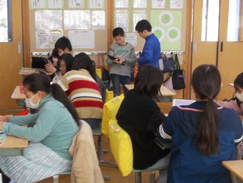 教室内で生徒たちがタブレットを使い、お互いに教え合ったり、協力して学習に取り組む様子を捉えた写真