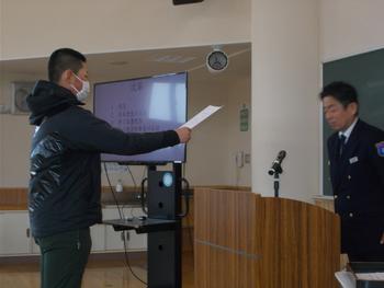 教室内で、代表の男子児童が教壇の前に立つ佐藤署長から修了書を受け取っている様子の写真