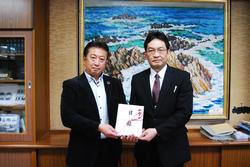 スーツ姿の同窓会長様から三浦校長へ目録の寄贈が行われている写真