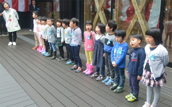 カメラの方を向いて大きな口を開け、元気な歌を歌っている幼稚園児や保育園児たちの写真