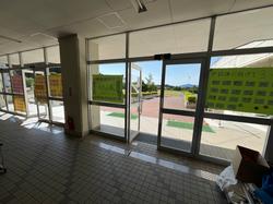 昇降口のガラス扉に中総体に懸ける思いを書いた黄緑色や黄色の大きな掲示物が飾られている写真