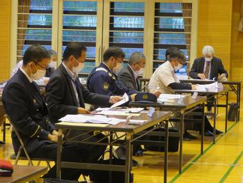 長机に資料を開き着席している防災教育推進委員会に参加している人達を斜め前から写した写真