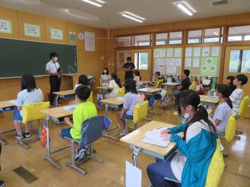 各自机に座り、前方の男性の説明を聞いている教室内での写真