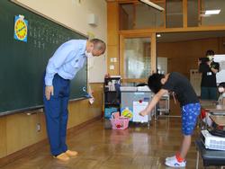 教室の黒板の前に立つ及川所長さんと児童が互いに深く礼をしている写真