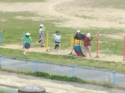 1人の児童が逆上がり練習器を使い逆上がりの練習をしている所を見学したり児童が集まってきている写真