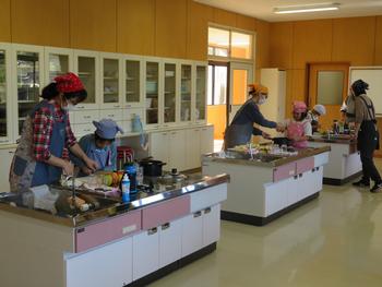 3組の親子が3つの調理台にわかれ料理をしている写真