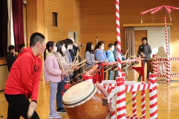 体育館内で太鼓をたたきながら入谷打囃子の発表をしている子供たちの写真