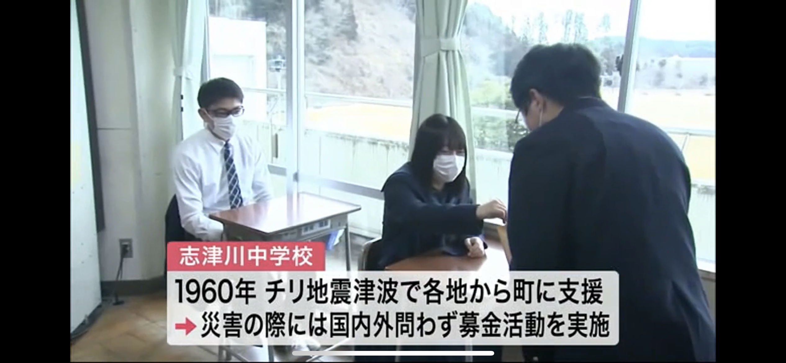 「志津川中学校」「1960年 チリ地震津波で各地から町に支援&rarr;災害の際には国内外問わず募金活動を実施」の字幕スーパーと、教室で募金箱に募金をする女子生徒の様子が映ったテレビ画面の画像
