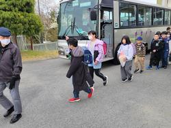 バスの横に運転手さんを先頭に縦に一列になった児童達が歩き始めた写真