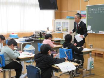 男性教諭が一番前の席の子供たちの近くに立ち授業を進めている写真