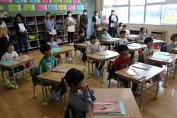 教室後方で保護者の方々が見守る中、授業参観が行われている様子の写真