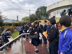 階段に集まった制服姿の学生たちが、それぞれ屋外で募金活動をしている様子の写真