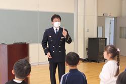 南三陸消防署歌津出張所の所長さんが生徒たちの前に立ち、少年消防クラブ入団式が行われている様子の写真