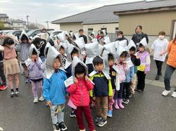 防災頭巾をかぶった生徒ちが、建物前の屋外で整列している写真