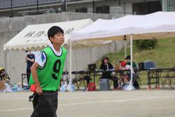 胸には「9」という数字が黒く書かれている緑色のビブスを着ている男子児童の障害物競走での写真