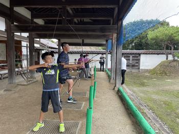 弓道体験をしている子供たちを弓を構えている横から写した写真