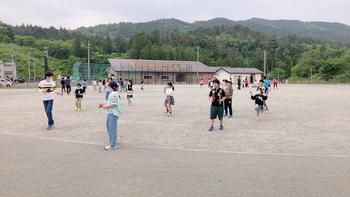 子ども達が運動場に並んで先生の真似をしながら練習する、よさこいの練習風景を撮影した写真