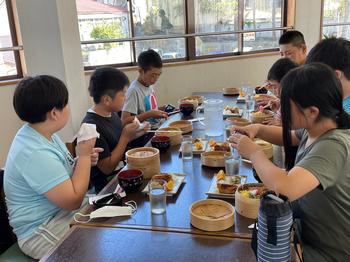 楽しそうな食事でわっぱ飯を食べている児童達7名の写真