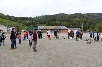 早朝作業に参加した方々が運動場に集まっている様子の写真