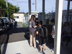 自動車が縦列に並び、その横で引渡訓練が行われている様子の写真