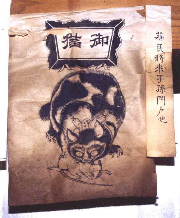 紙の上部に「御猫」という文字があり、中央にはネズミをくわえた猫の絵が墨で力強く描かれている御札の写真