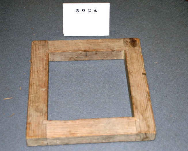 木の枠だけで出来た四角い漁業用道具の海苔枠の写真