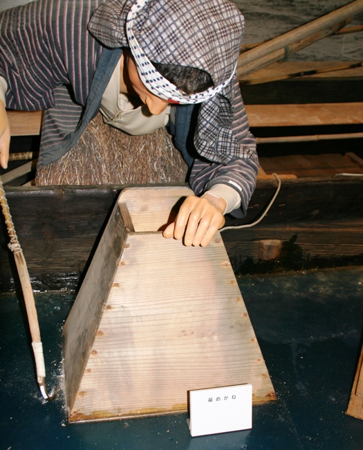 漁師の人形が船の中から木箱の底にガラスをはめ込んだ船上漁の道具の中を覗き込み、槍を刺してアワビなどを採取している箱めがねの展示の写真