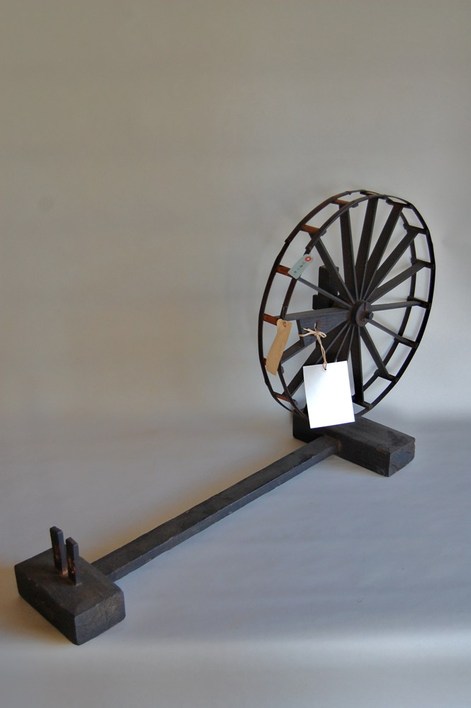 大きな車輪と横木で構成された手回し式の糸車の写真