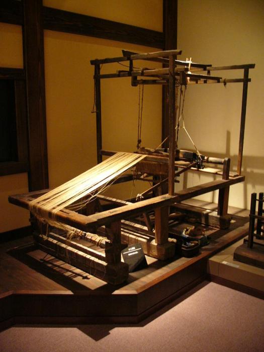 室内に展示された大きな木製の「はたおり機」の写真