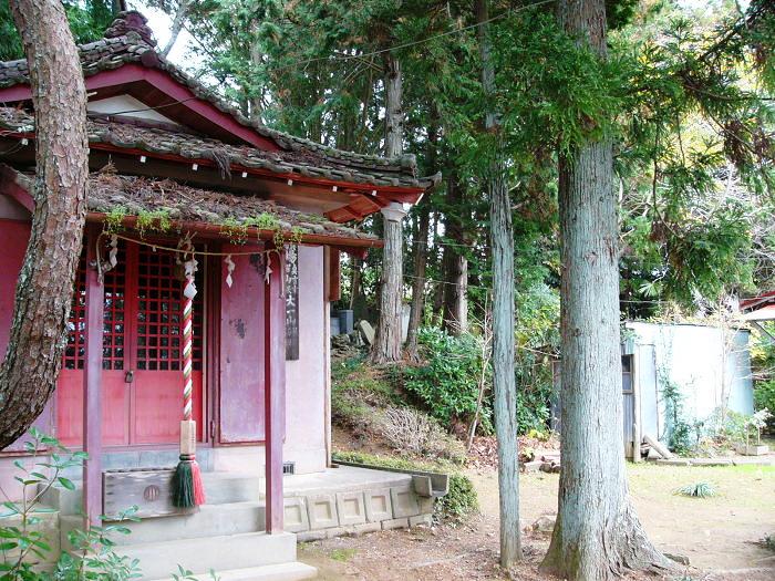 赤い柱と扉が特徴の木々に囲まれた場所にある大一山海円寺の写真