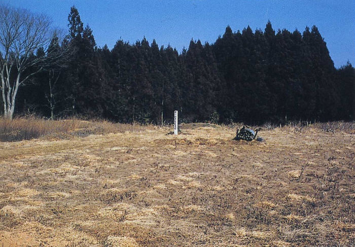 白色の標柱のそばに乾いた草地が広がっている長者屋敷遺跡の写真