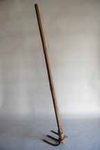 木の柄がついた三本の刃を持つ農具の三本鍬の写真