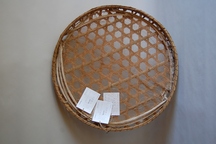 竹製で網目状に編まれた丸い竹ざるのかごわらだの写真