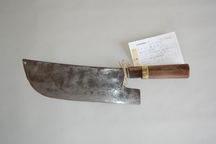 木の持ち手と、幅が広くて平らな鉄の刃がついた桑切包丁の写真