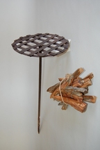 紐で束ねられた焚き木と、鉄製の棒に付けられた格子状の丸い焼き網の「松とうがい」の写真