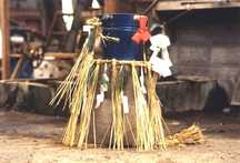 土間に敷いた藁の上に、注連縄が飾られた伏せて置かれた臼、臼の上には若水桶を載せた臼伏せの写真