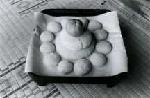 折敷に紙を敷き、その上に大小二段に重ねられた鏡餅と橙、さらに周囲に小さな餅が12個並べられている「十二のおそなえ」を写した白黒写真