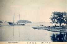 水尻川口を写した風景で、大型の帆船が停泊する川の河口に浮かぶ小舟や小島、木々が茂る岸辺が見える古い写真