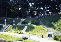 石灯籠や岩、小道が配置され、苔や木々に囲まれた山内甚之丞・甚兵衛父子の墓所の写真